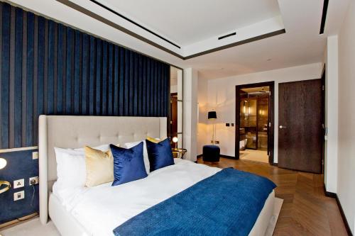 a bedroom with a large bed with blue pillows at 37GS Residences in London