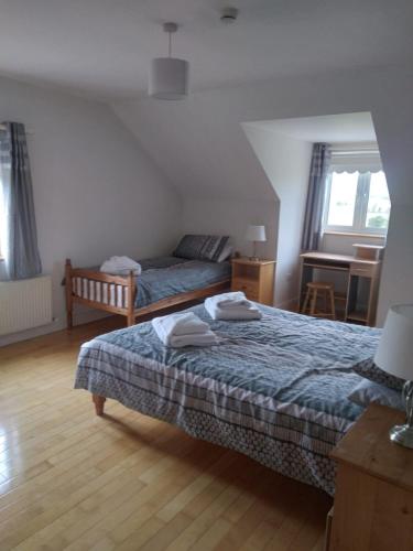 a bedroom with two beds and a table and a desk at Abbeywest House 