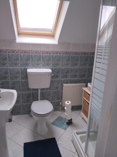 a bathroom with a toilet and a sink and a window at Abbeywest House 