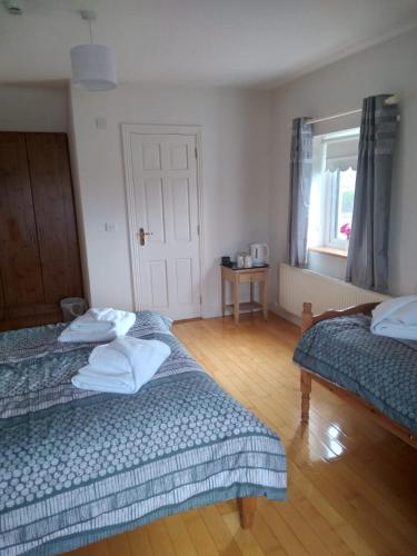 a bedroom with two beds and a window at Abbeywest House 