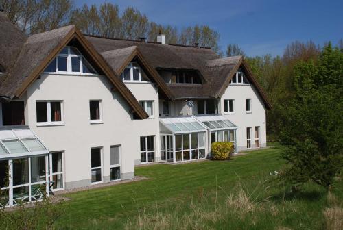 ein großes weißes Haus mit braunem Dach in der Unterkunft Strandhaus Lobbe - Fewo 45499 in Lobbe