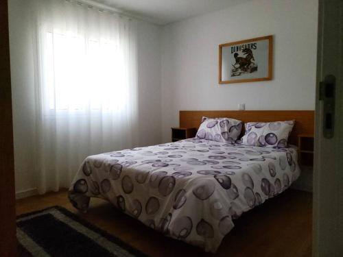 1 dormitorio con cama con edredón y ventana en Monte dos Pastorinhos, en Fátima