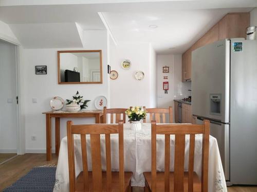 a kitchen with a table with chairs and a refrigerator at Monte dos Pastorinhos in Fátima