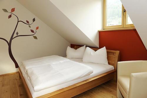 1 dormitorio con 1 cama con un árbol en la pared en Premium Appartements Di Bora, en Sankt Michael im Lungau