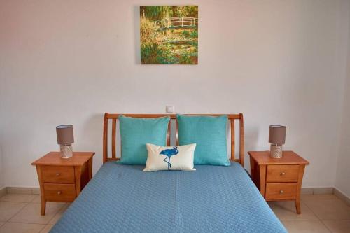 a bedroom with a blue bed with two night stands at Apartamento T3 encantador com piscina wifi e perto de praia in Santa Maria