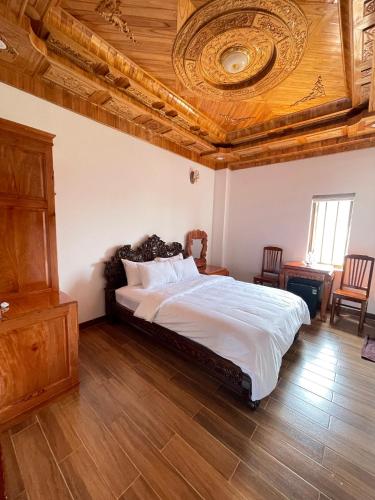 a bedroom with a large bed with a wooden ceiling at Hotel Hoàng My in Pleiku