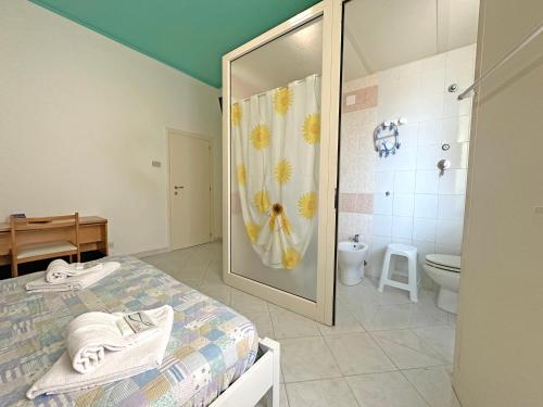 a bathroom with a bed and a shower and a toilet at Affittacamere I Gigli di Mare in Marina di Bibbona