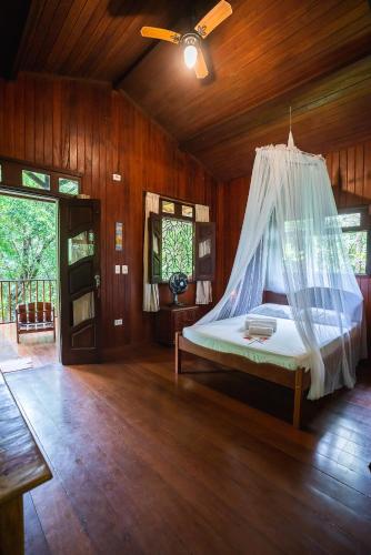 a bedroom with a bed with a mosquito net at Anjali in Ilha de Boipeba