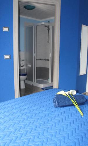 a blue bedroom with a bed and a mirror at B&B Fontevecchia in Castelsardo