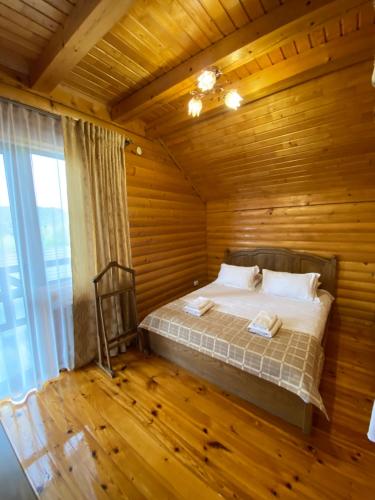 a bedroom with a bed in a wooden room at Dachna Sadyba PB in Migovo