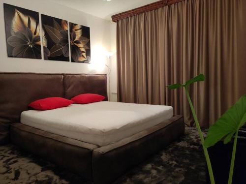 - une chambre avec un lit et 2 oreillers rouges dans l'établissement Elpa, à Belgrade