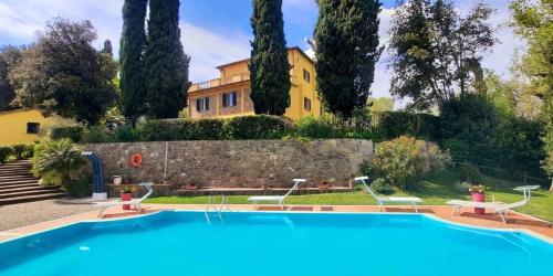 a villa with a swimming pool in front of a house at Fattoria La Palazzina in Radicofani