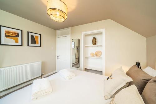 a bedroom with a white bed and a couch at Clubhouse Cottage on Eden View Estate in St. Andrews