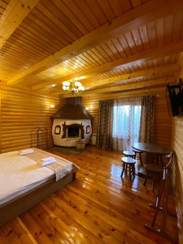 a bedroom with a bed and a room with a fireplace at Dachna Sadyba PB in Migovo