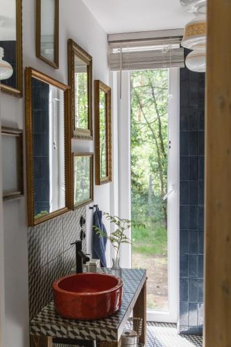 a bathroom with a red tub on a counter at Tu, Tam i Tamten Domek in Wojtyniów