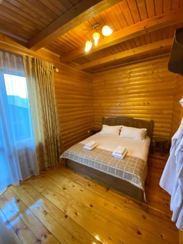 a bedroom with a bed in a wooden room at Dachna Sadyba PB in Migovo
