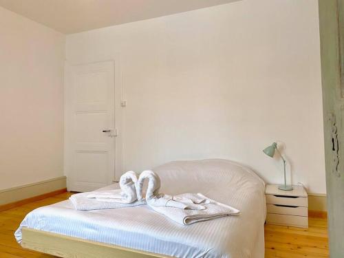 a white bed with towels on it in a room at Etage privé dans Maison de Maître 