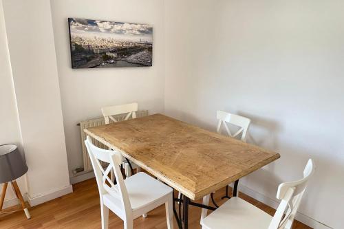 uma sala de jantar com uma mesa de madeira e cadeiras brancas em Apartment with sea views next to the beach of Mar Bella em Barcelona