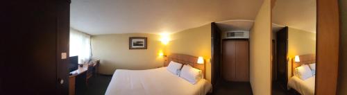 um quarto de hotel com duas camas e uma janela em Kyriad Tarbes Odos em Odos