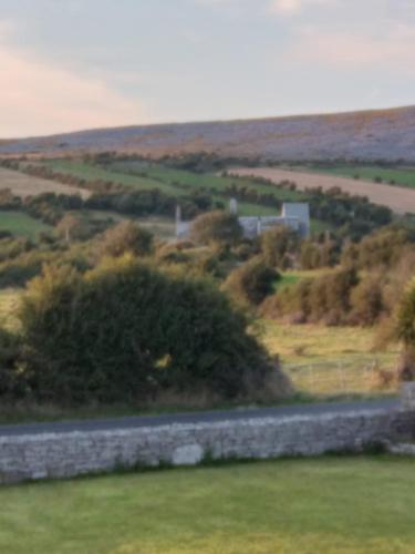 a road in a field with a stone wall at Abbeywest House 