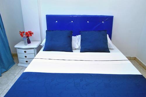 a blue and white bed with a blue headboard and pillows at Ayenda Hotel Roisa in Girardot