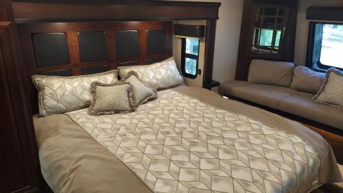 a bedroom with a large bed and a couch at Hill Country Luxury RV Glamp: Twin Falls, Texas in Boerne