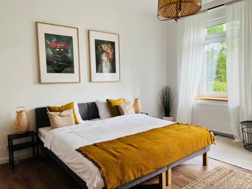 Un dormitorio con una cama grande con una manta amarilla. en Apartament Turystyczna 22, en Szklarska Poręba