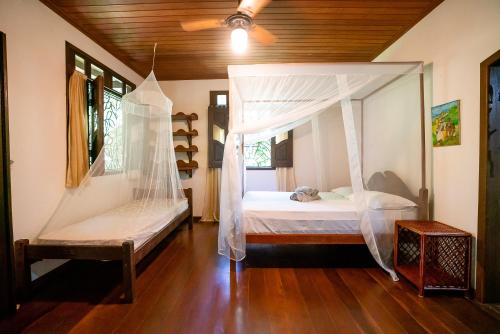 a bedroom with two beds and a ceiling fan at Anjali in Ilha de Boipeba