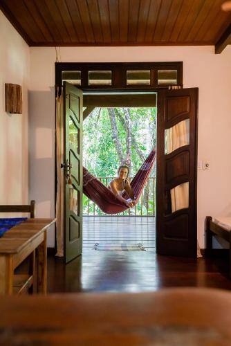 a woman lying in a hammock in a room at Anjali in Ilha de Boipeba
