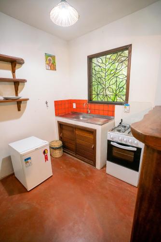 a kitchen with a sink and a stove at Anjali in Ilha de Boipeba