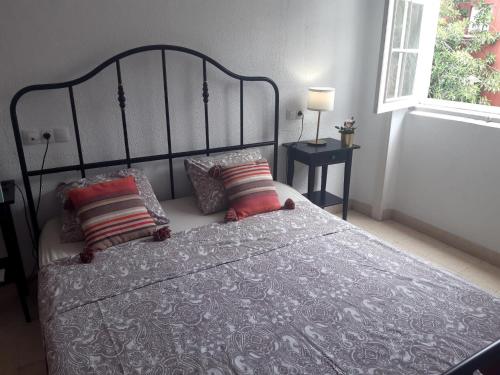 a bedroom with a bed with two pillows and a window at Nomad Villa Santa Fe in Las Palmas de Gran Canaria