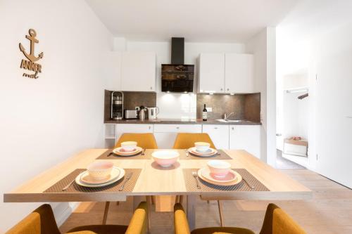 uma cozinha com uma mesa de madeira com cadeiras e uma sala de jantar em Wohnung Peper em Juist