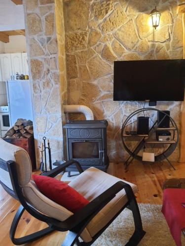 a living room with a chair and a fireplace at Vacation Home Andjelic in Žabljak