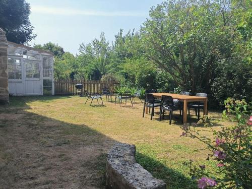 una mesa de picnic y sillas en un patio en LE SEIZE - Gîte 4 personnes - entre Caen et la mer, en Cairon