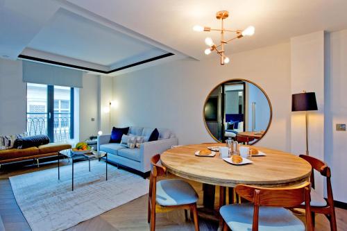 uma sala de estar com uma mesa e um sofá azul em 37GS Residences em Londres