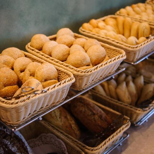 a bunch of baskets filled with different types of bread at Enotel Magnólia in Funchal