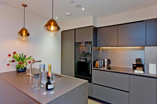a kitchen with a counter with wine glasses on it at 37GS Residences in London