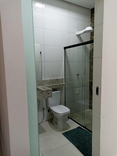 PIRANHAS HOTEL في ببرانا: حمام مع مرحاض ودش زجاجي