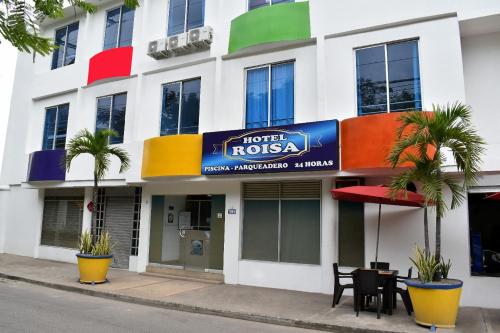 a hotel iglia with palm trees in front of a building at Ayenda Hotel Roisa in Girardot