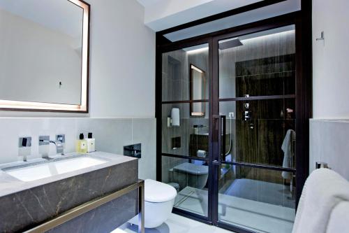 a bathroom with a sink and a toilet and a shower at 37GS Residences in London