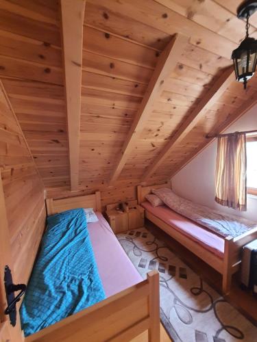 a bedroom in a log cabin with two beds at Vacation Home Andjelic in Žabljak