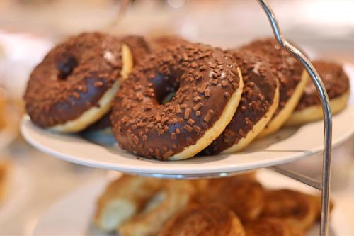a plate with chocolate donuts and other pastries on it at Enotel Magnólia in Funchal