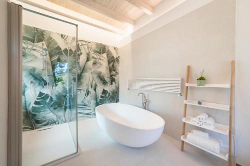 La salle de bains est pourvue d'une baignoire et d'une douche en verre. dans l'établissement Agriturismo Acquachiara, à Sabaudia