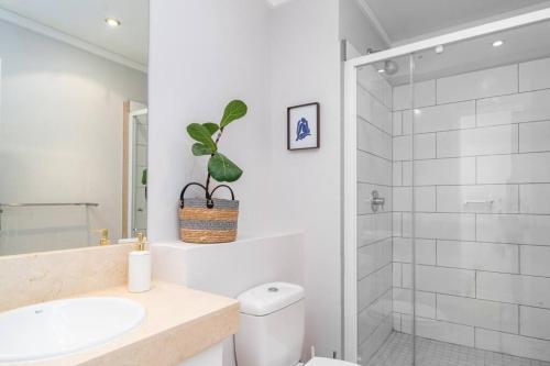 a bathroom with a toilet and a sink and a shower at Cozy Ocean View Apartment in Cape Town