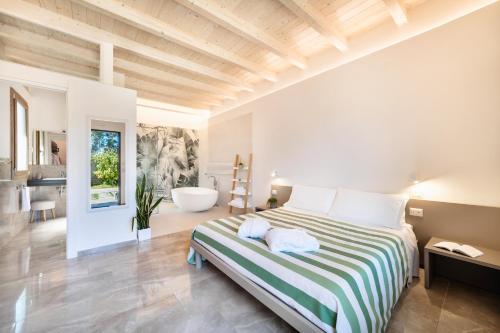 - une chambre avec un grand lit et une baignoire dans l'établissement Agriturismo Acquachiara, à Sabaudia