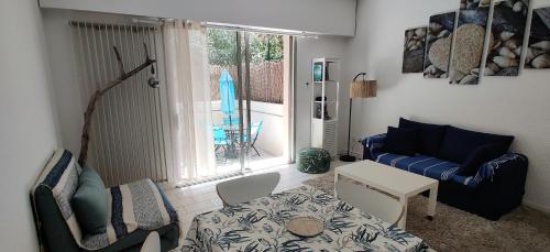 a living room with a blue couch and a table at Studio avec terrasse en bord de mer Marseille in Marseille