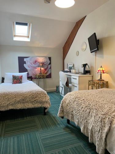 a bedroom with two beds and a desk at The Crown Lodge Bed & Breakfast in Dogdyke