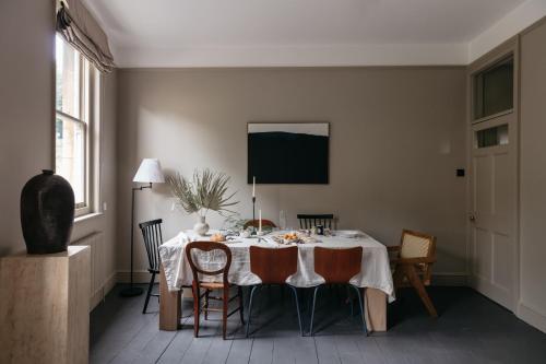 een eetkamer met een tafel en stoelen bij The Curator's Apartment - 2 Bedrooms with parking in Bath