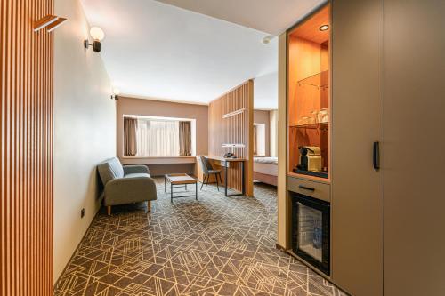a living room with a couch and a chair in a room at HOTEL CENTRAL Pascani in Paşcani