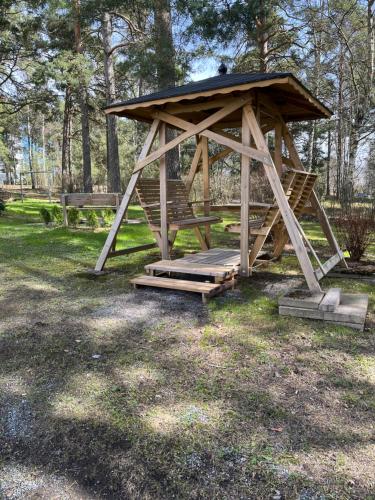 a wooden gazebo in a park with trees at Compact apartment in Rauma in Rauma